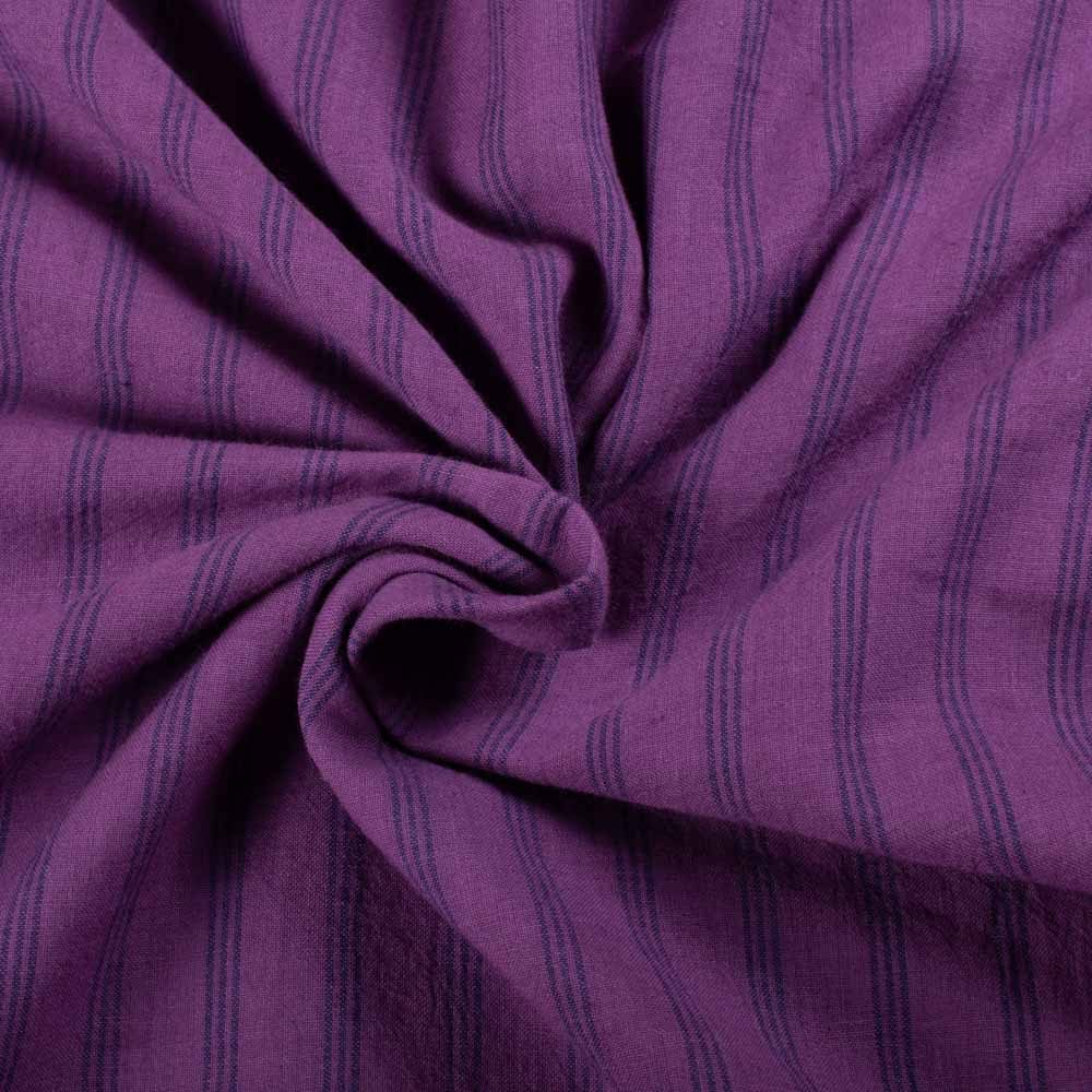 Twisted view of blue and white stripe cotton fabric showing drape and flexibility