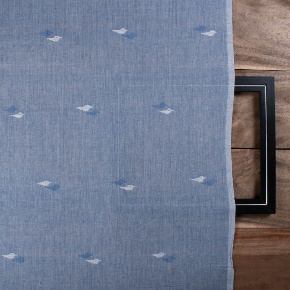 Full-width view of blue plain cotton Jamdani fabric with repeating white arrow motif pattern